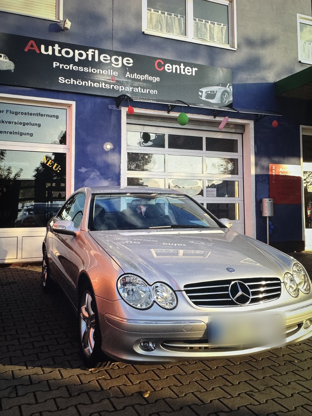 Silberner Mercedes vor der Halle des Autopflege Centers im Jahr 2012