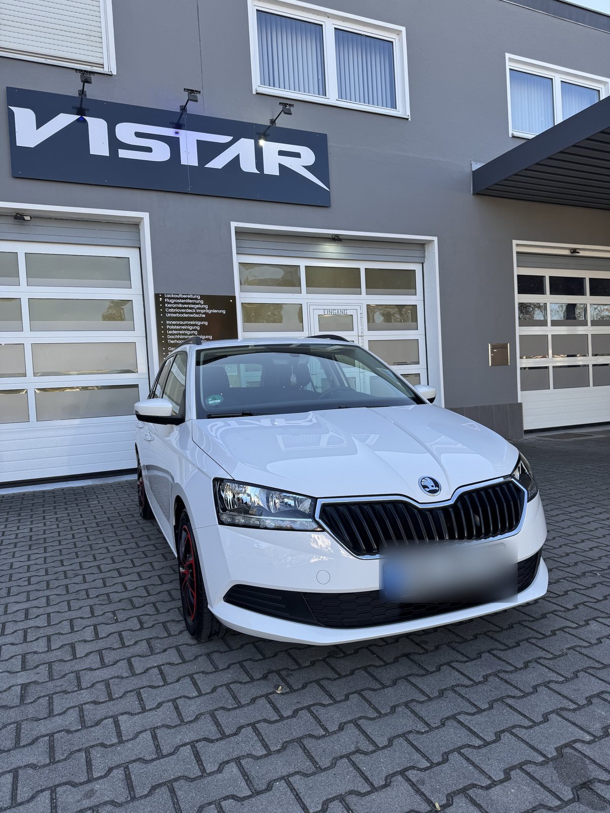 Weisser Skoda vor derselben Halle mit VISTAR Schriftzug im Jahr 2026